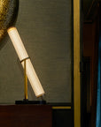 La Lampe Frechin table lamp by DCW Editions in a dark theme interior next to a wall mirror.