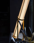 La Lampe Frechin table lamp by DCW Editions lit up on a window sill.