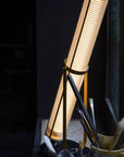 La Lampe Frechin table lamp by DCW Editions lit up on a window sill.