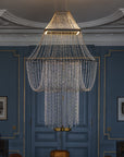 Chandelier hanging in a room with blue walls and decorative molding.