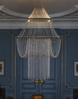 Chandelier hanging in a room with blue walls and decorative molding.