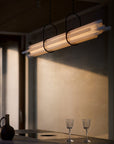 NL12 Suspension chandelier from DCW Edition above a long table styled with water jug and crystal glass