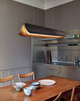 Respiro suspension lamp in brass from DCW Editions above a dining table