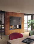 A modern interior scene featuring a wall-mounted black gas fireplace with a wood-look surround, set in a contemporary living space with dining chairs, a table, and a large potted plant.