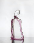 Glass sculpture of a woman with a purple tint on a white background titled HER from Duccio Di Segna, available at Spacio retail stores in Mumbai & Kolkata.