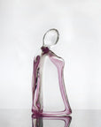 Glass sculpture of a woman with a purple tint on a white background titled HER from Duccio Di Segna, available at Spacio retail stores in Mumbai & Kolkata.