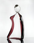 Glass sculpture of a man with a violet tint on a white background titled HIM from Duccio Di Segna, available at Spacio retail stores in Mumbai & Kolkata.