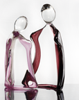 Artistic glass sculpture of two abstract figures titled Him & Her from Duccio Di Segna on a white background available at Spacio retail stores in Mumbai & Kolkata.