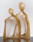 Artistic glass sculpture of two abstract figures with 24K gold dust titled Him & Her from Duccio Di Segna on a white background available at Spacio retail stores in Mumbai & Kolkata.