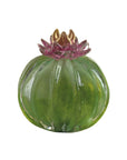 Green glass pumpkin with pink flower on a white background