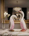 Decorative duck figures on a marble surface with a mirror and chandelier in the background.