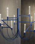 Modern blue chandelier with multiple light fixtures against a neutral background