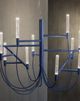 Modern blue chandelier with multiple light fixtures against a neutral background