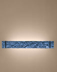 Decorative wall sconce with textured design on a beige wall