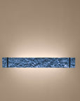 Decorative wall sconce with textured design on a beige wall