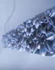 Close-up of a floral-patterned ceramic suspension lamp on a light background