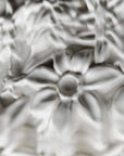 Close-up of white ceramic flowers of the Fregio lamp from Foscarini with a glossy finish