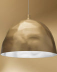 Gold pendant light against a beige background