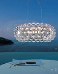 Modern chandelier hanging above a dining table with a scenic background