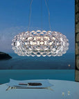 Modern chandelier hanging above a dining table with a scenic background