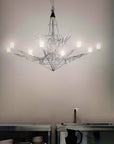 Modern chandelier hanging in a kitchen with neutral walls and minimal decor.