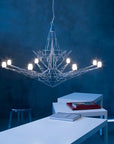 Modern chandelier hanging in a room with blue walls and white furniture.