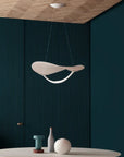 Modern pendant light hanging in a room with dark walls and a wooden ceiling.
