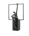 Abstract sculpture of a figure sitting on a square base with a rectangular frame above.