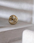 Gold finish bronze object on a textured surface