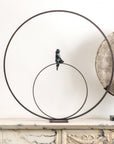 A Gardeco Bronze Sculpture Lost in Thoughts (Limited Edition) of a bird sitting on a circle, created using the lost wax method.