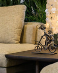 Beige sofa with decorative sculpture on a table and chandelier in the background