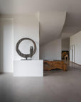 Modern interior with a sculpture on a pedestal and a textured wall.