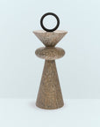Decorative stone sculpture with a circular top on a light blue background