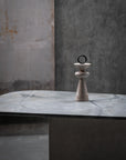 Decorative stone sculpture on a marble surface with a textured wall background