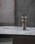 Decorative stone sculpture on a marble surface with a textured wall background