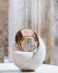 Decorative sculpture with gold and white design on a neutral background