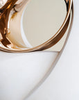 Gold finish bronze decorative item on a white surface