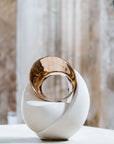 Decorative sculpture with gold and white design on a neutral background