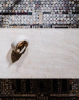 Decorative wall with mosaic pattern and a white bowl with gold interior