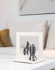 Bronze & stone sculpture of a family on a coffee table in a living room.