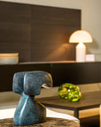 Decorative blue green patina sculpture on a table with a blurred background