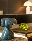 Decorative blue green patina sculpture on a table with a blurred background