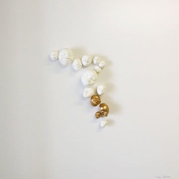 A group of Gardeco Wall Sculpture Happy Faces on a white surface, created by Brazilian ceramist Selma Calheira.