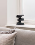 Decorative metal sculpture on a windowsill with a neutral color palette