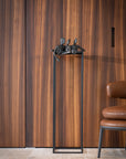 Decorative sculpture from Gardeco called Lets Talk on a stand against a wooden panelled wall with a chair partially visible.