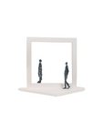 Abstract sculpture of two figures inside a square frame on a white background