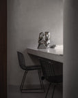 Modern interior with a desk and chairs in a minimalistic setting and the Shifting Perspectives limited edition bronze sculpture from Gardeco