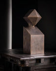 Abstract metallic sculpture on a dark surface with a black background