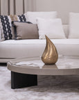 Modern living room with a marble coffee table and decorative teardrop sculpture.