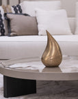 Modern living room with a marble coffee table and decorative teardrop sculpture.